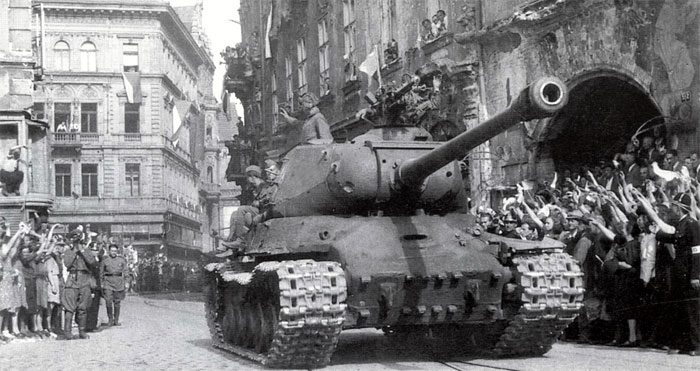 ИС-2 из состава 1-й чехословацкой танковой бригады на одной из центральных улиц Праги. 10 мая 1945 года. На лобовой броне башни этого танка, слева от пушки, отчетливо видна вмятина от попадания немецкого снаряда.